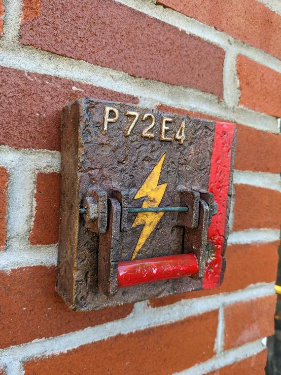 Box Tile “P72E4 Switch” (2024) Red stoneware, oxide washes, underglaze, glaze, nichrome rod, upcycled glass. Electric fired. Wall piece.