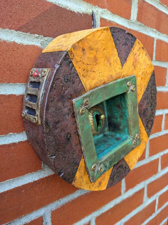 Bang Switch II (2024). Red stoneware, glass, oxide washes, underglaze, glaze. Electric fired. Cold worked. Wall piece. Rondeau.